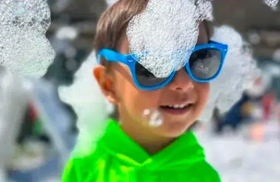 Enfants s’amusant dans une fête en mousse pour camp de jour avec canon à mousse Wow Foam
