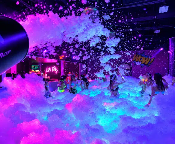 Enfants lors d’une fête en mousse intérieure Wow Foam, avec mousse, musique et éclairage