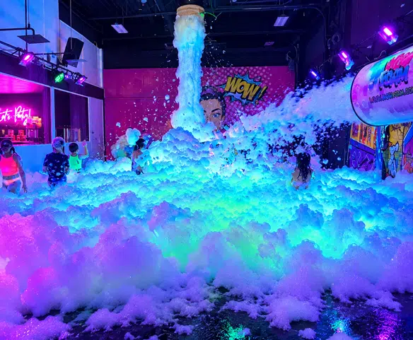 Enfants lors d’une fête en mousse intérieure Wow Foam avec musique et éclairage