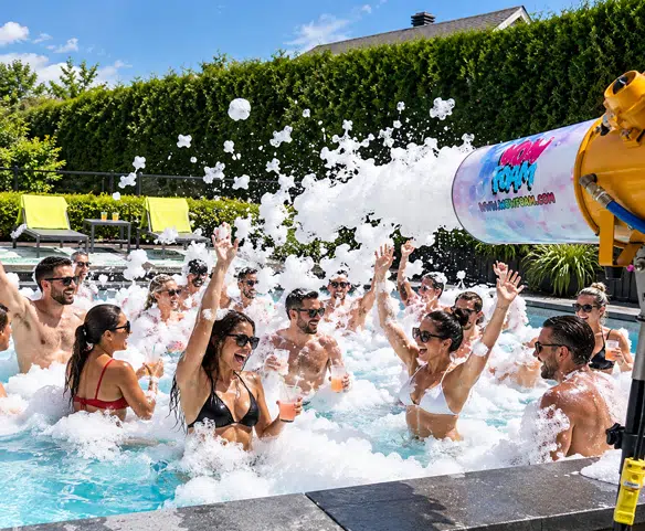 Enfants jouant dans une fête en mousse à domicile avec un canon à mousse et musique