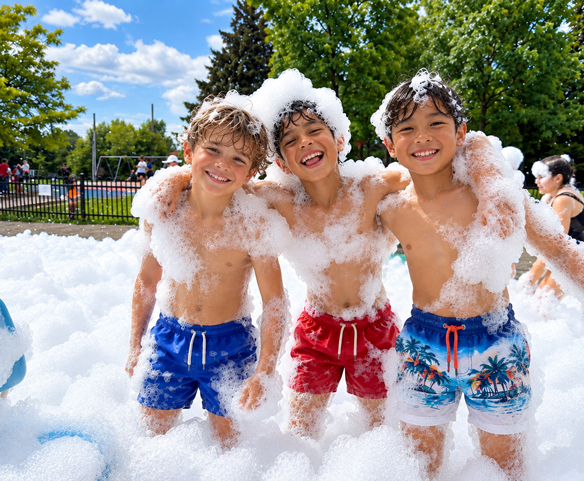Enfants participant à une fête en mousse à l'école avec une machine Wow Foam