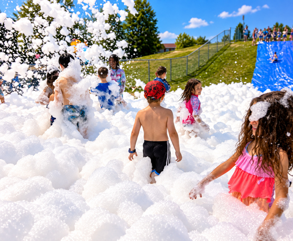 Enfants participant à une fête en mousse à l’école avec une machine Wow Foam