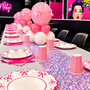 Elegant table setup with tablecloth, cups, plates, utensils, napkins, and three balloon centerpieces.