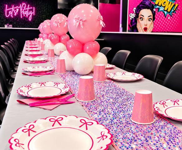 Elegant table setup with tablecloth, cups, plates, utensils, napkins, and three balloon centerpieces.