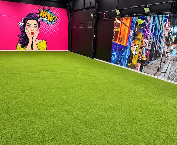 Salle de mousse Wow Foam à Laval avec gazon synthétique et murales colorées