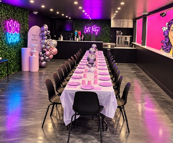 Salle de réception Wow Foam à Laval avec longue table décorée, ballons et néons