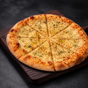 Pizza ronde au fromage sans sauce, parmesan, mozzarella et huile d’olive