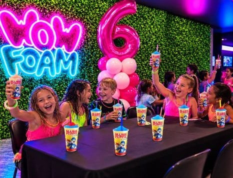 Promotions 1 Promotions Enfants qui lèvent leur slush lors d’une fête d’anniversaire Wow Foam avec colonne de chiffre